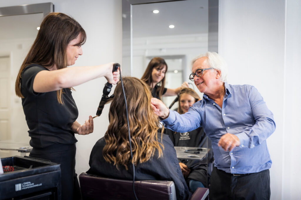 A customer getting their haircut by two staff members at Expressions Hair hairdresser in Midhurst, West Sussex.