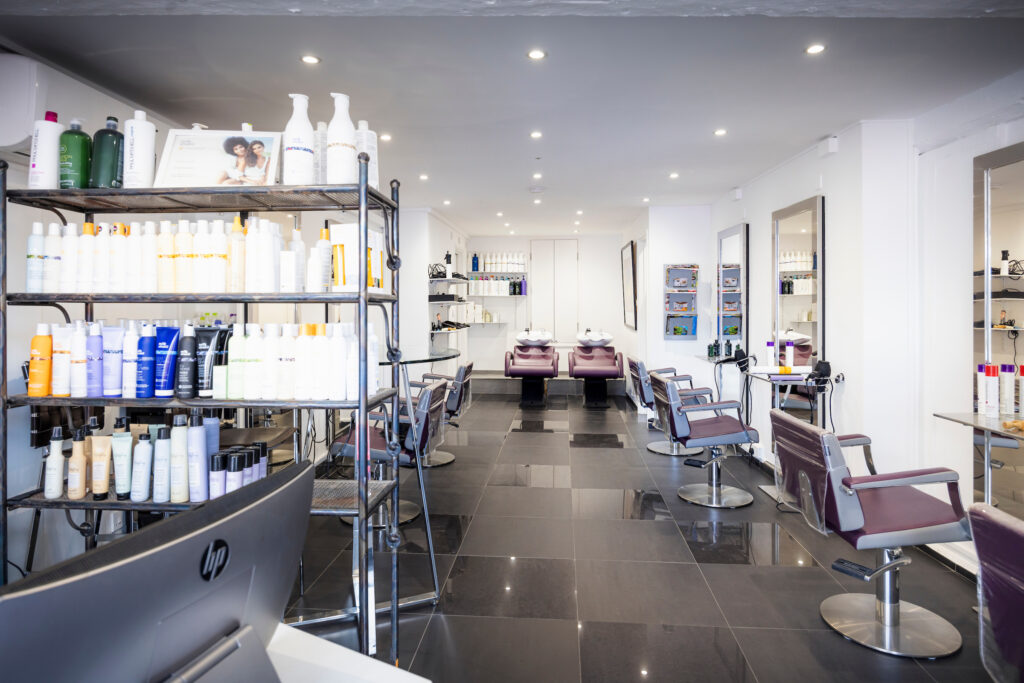 An interior view of Expressions Hair hairdressers in Midhurst, West Sussex. Showcasing the salon chairs and hair products.