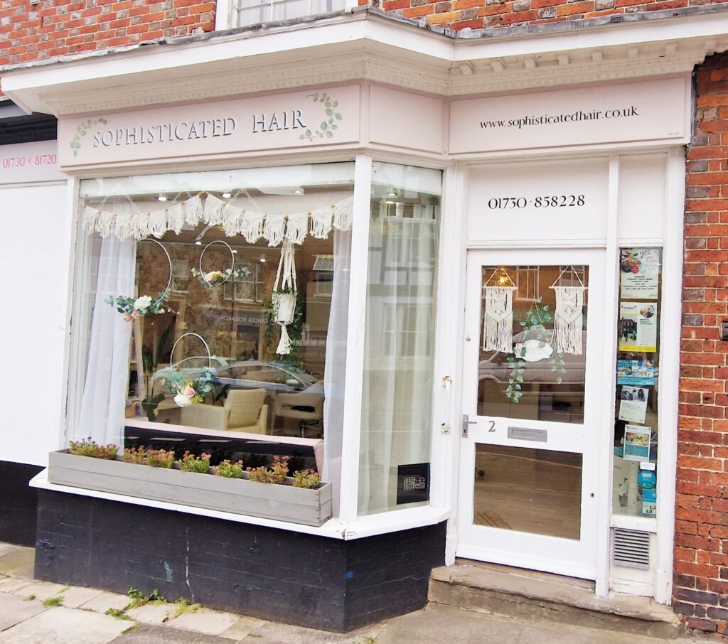 The pink exterior shop front of Sophisticated hair hairdresser in Midhurst, West Sussex.