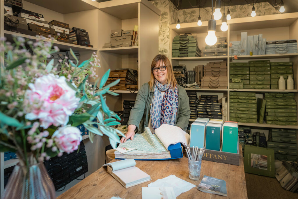 A staff member inside the shop of The Upholsterer, interior design and upholstery on North Street in Midhurst, Sussex.