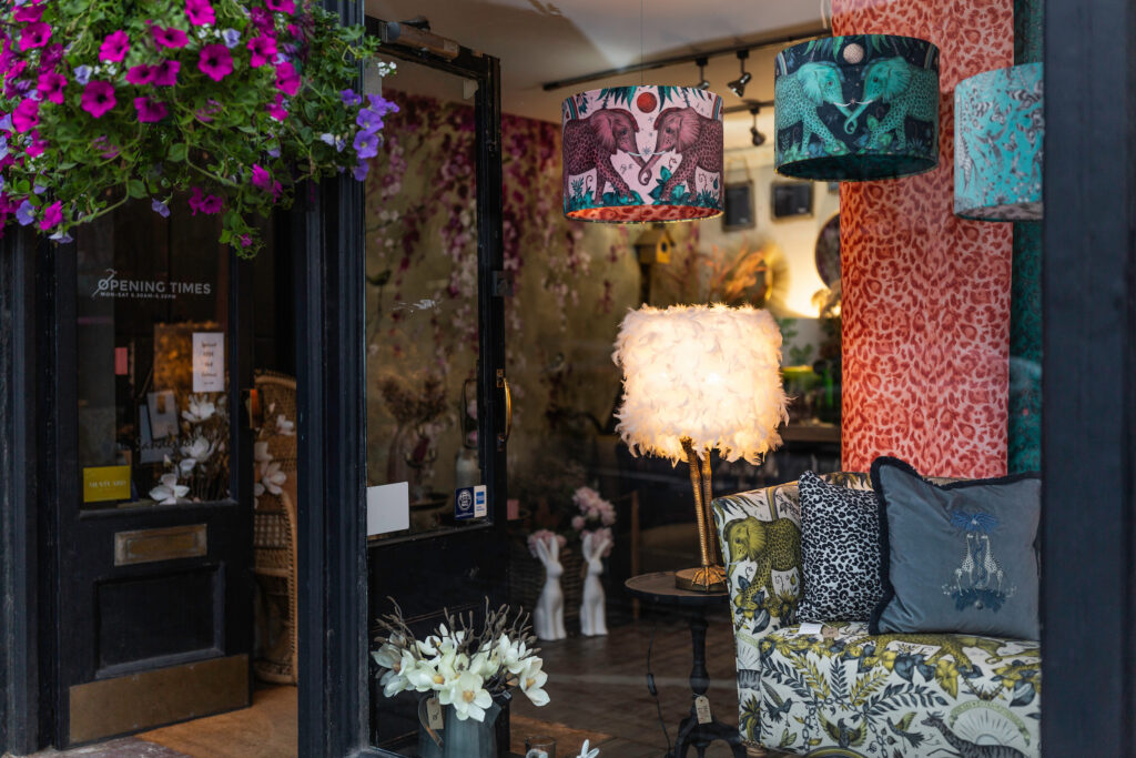 A view of the shopfront of The Upholsterer in North Street, Midhurst showcasing a range of colourful furniture designs.