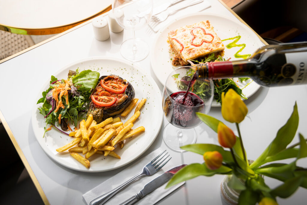 A top down view of a Kemaelli's cafe lunch with a glass of wine on a white table, Midhurst, West Sussex.