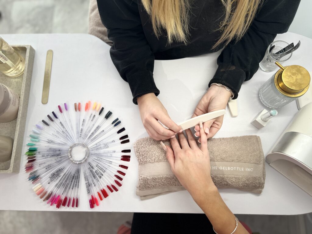 A top down view of a customer getting a manicure against a whit table at Emma O'Malley Hair and Beauty in Midhurst, West Sussex.