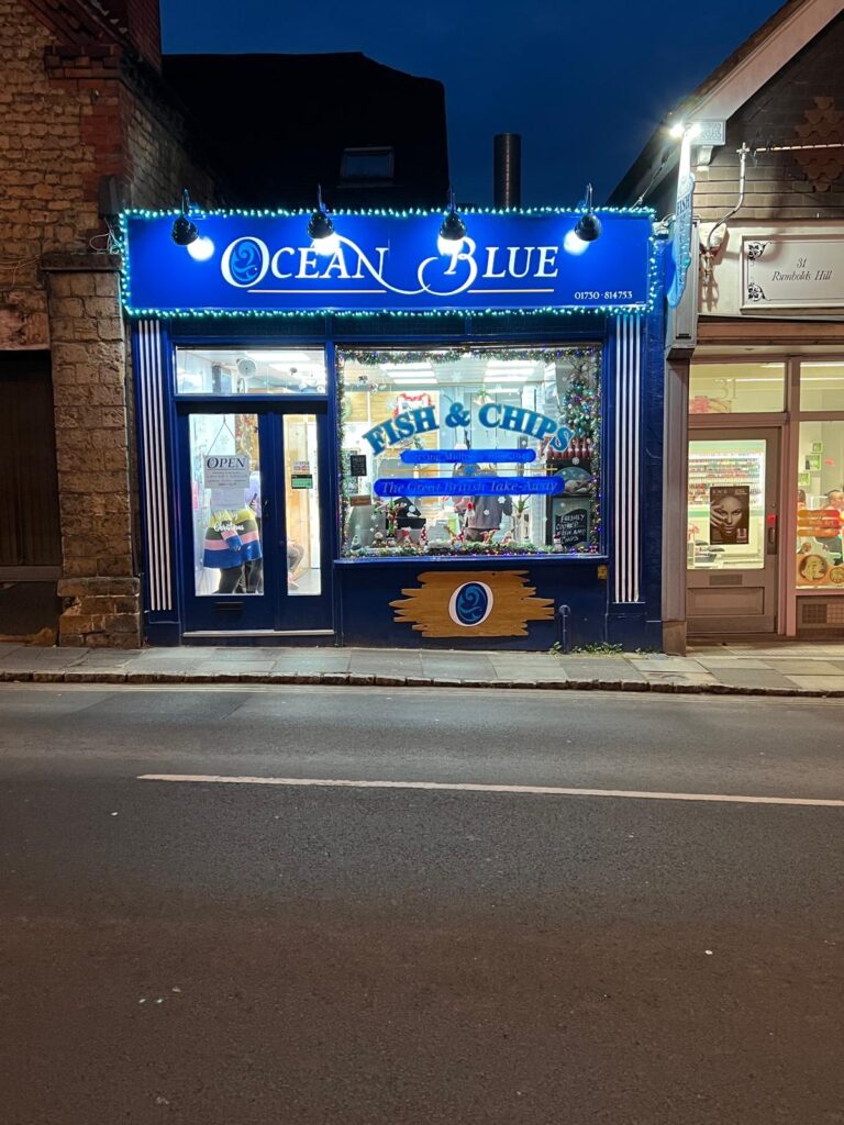 A street view at night of Ocean Blue fish and chips, Midhurst, West Sussex.