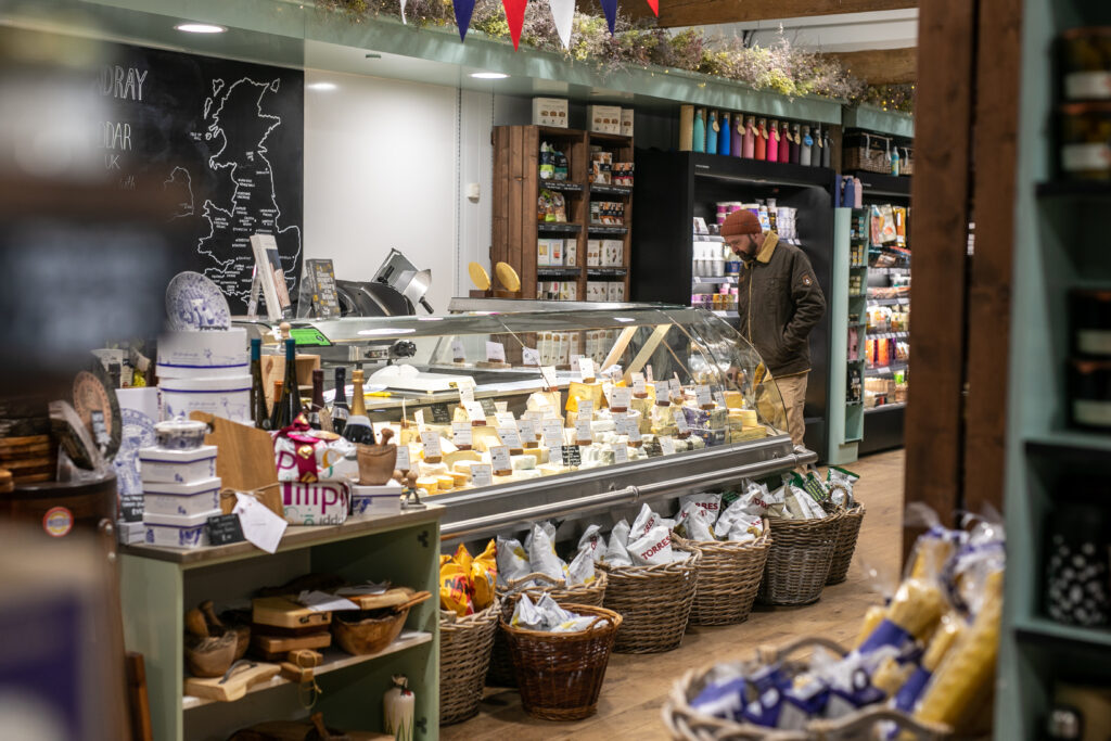 A view of the cheese counter with a customer inside the Cowdray Farm Shop in Midhurst, West Sussex.