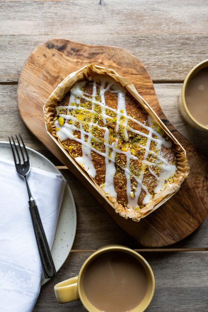 A closeup of baked goods and cups of tea on a wooden table at Cowdray Farm Shop & Cafe in Midhurst, West Sussex.