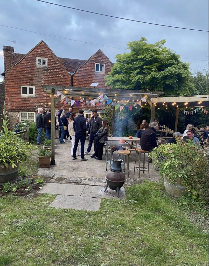 The garden of The Hollist Arms pub in West Sussex with many pub goers.