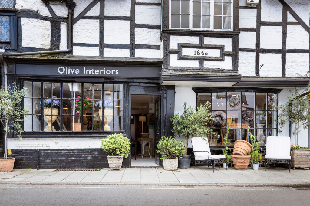 Exterior of Olive Interiors in West Street Midhurst with furniture and plants outside.